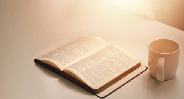 Open a bible by the window with a cup of coffee for the morning light. and put it on a wooden table with a window light Open a bible by the window with a cup of coffee for the morning light. and put it on a wooden table with a window light christian democratic union photos stock pictures, royalty-free photos & images