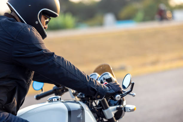 istock Side View Of Man Riding Motorcycle On Road 1334237752