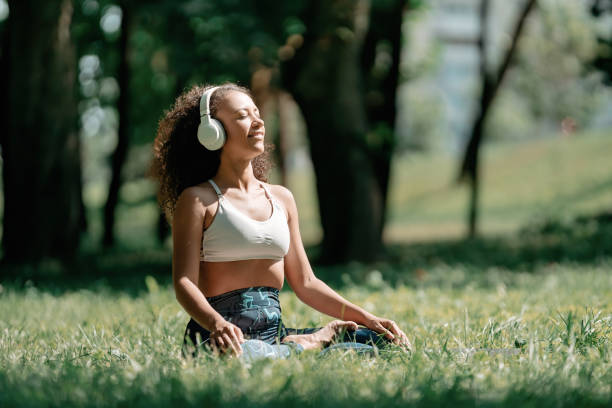 sporty woman in headphones relaxing to the music while sitting o stock photo