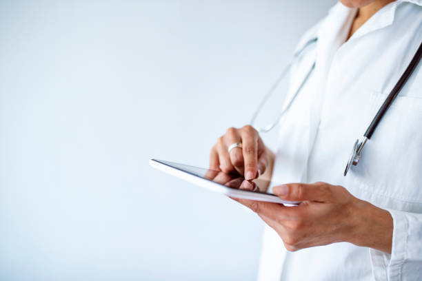 foto recortada de una doctora usando una tableta digital - digital tablet connection internet touching fotografías e imágenes de stock