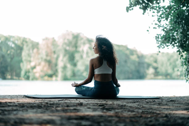 istock athletic young woman meditating outdoors . rear view 1334248881