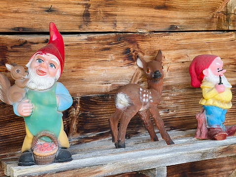 Dwarfs and a deer on old wooden patina background