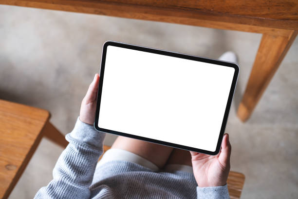 istock a woman holding digital tablet with blank white desktop screen 1334250117