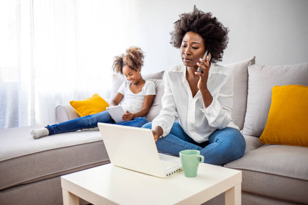 istock Smiling mom working at home with her child on the sofa while writing an email. 1334250714