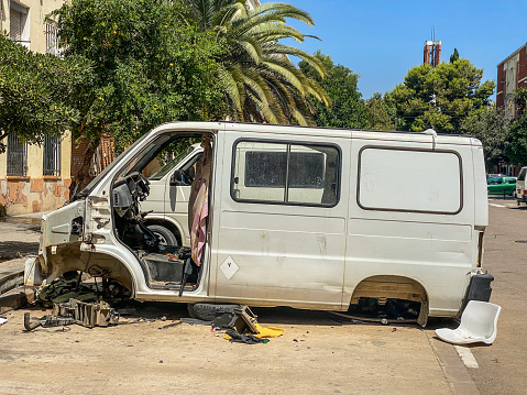 Valencia, Spain -  August 5, 2021: The bodywork of a minivan left in the street. It is possible that the parts were more valuable than the whole and the owner teared it apart