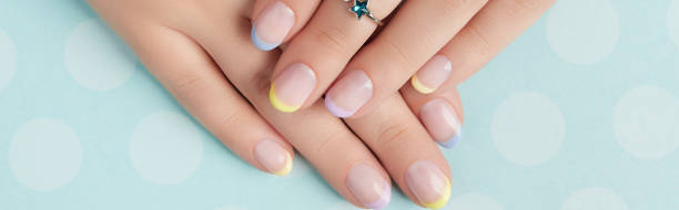 istock Beautiful womans hands with spring summer nail design on blue background 1334252181