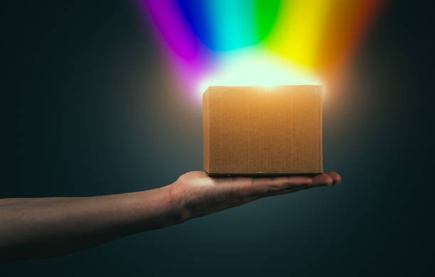 la mano dell'uomo tiene una scatola luminosa di luce arcobaleno - equal opportunity flash foto e immagini stock