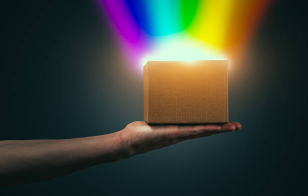 man's hand holds a box glowing with rainbow light - equal opportunity flash imagens e fotografias de stock