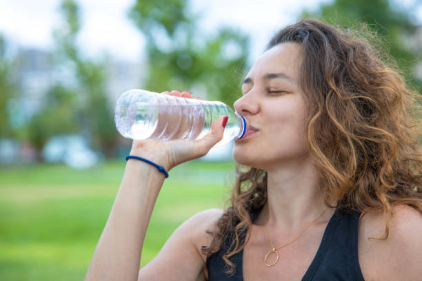 istock Young woman drinking water 1334256959