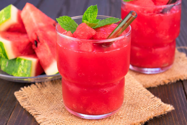 istock Two glasses with a refreshing drink watermelon with mint on a dark wooden background. 1334257959
