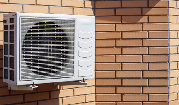 primo piano di una moderna unità di controllo del clima sullo sfondo di un muro di mattoni della facciata di una casa all'esterno. condizionatore d'aria sul muro con spazio per il testo. compressore d'aria - piccolo foto e immagini stock