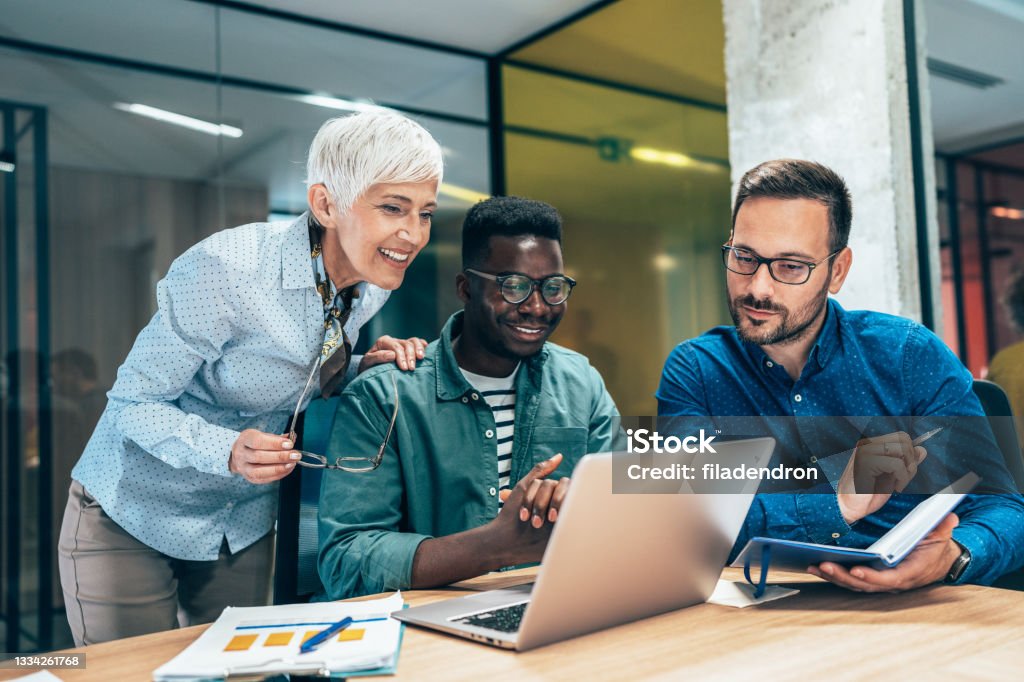 Business discussion Three multi-ethnic business people have a meeting in a modern office. Office Stock Photo