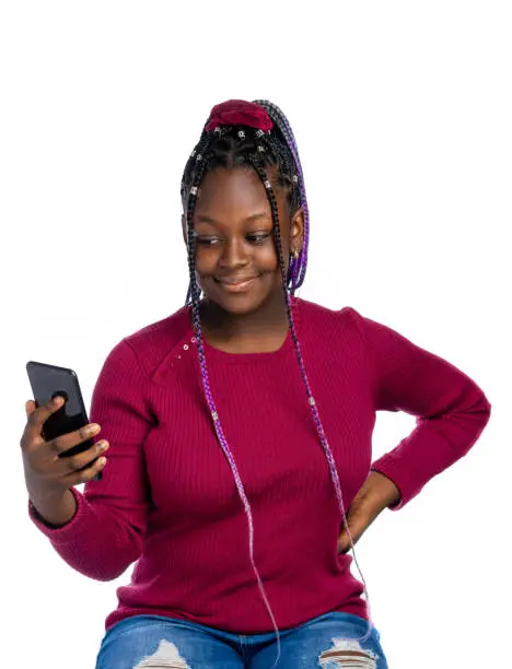 A smiling African Teenage girl posing for a selfie / looking into a smartphone