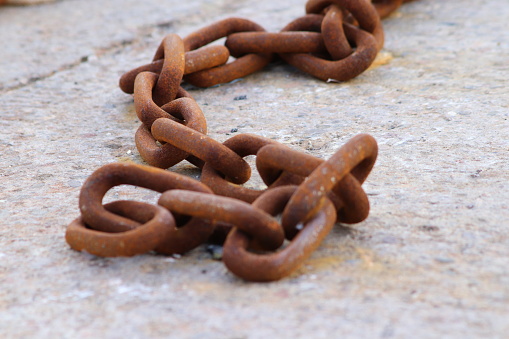 Close up of rusty old chain on concrete background