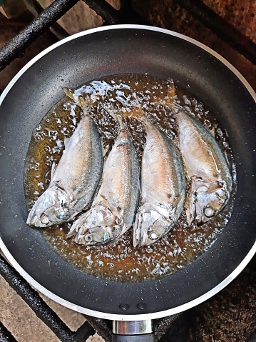 Fried mackerel in cooking pan.