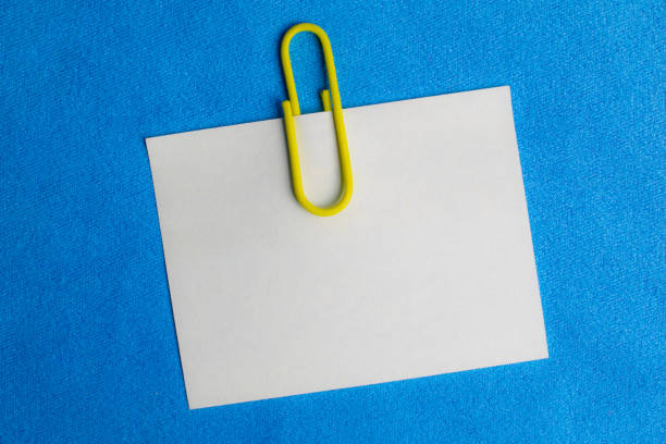 istock white blank note pinned to a blue notice board with a paper clip. 1334267163