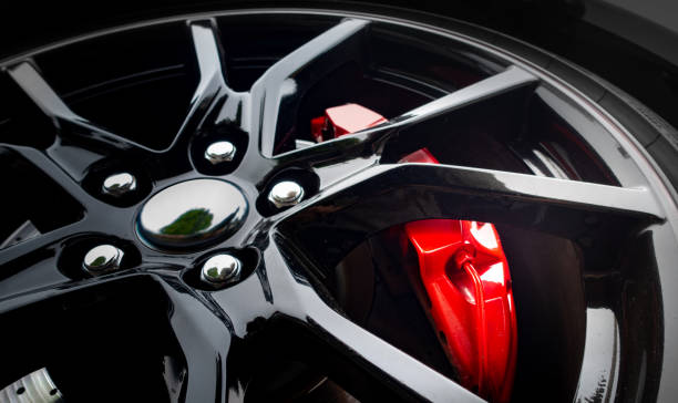современное легкосплавное колесо с красным тормозным цилиндром, видимым за ободом - wheel alloy alloy wheel tire стоковые фото и изображения