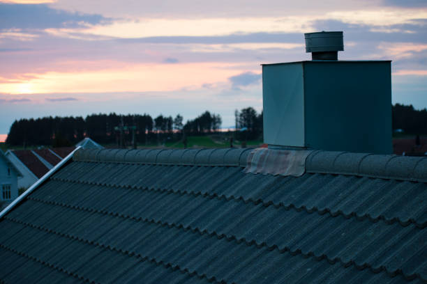 hauskamin mit wunderschönem küstenuntergang und leuchtturm im hintergrund - südnorwegen - vapor trail sky night sunset stock-fotos und bilder