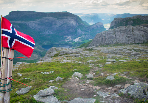 Norwegian flag with a Dramatic aerial view of lake town and fjords in background. Top of Fjords in Southern Norway - European Hiking and travel Concept