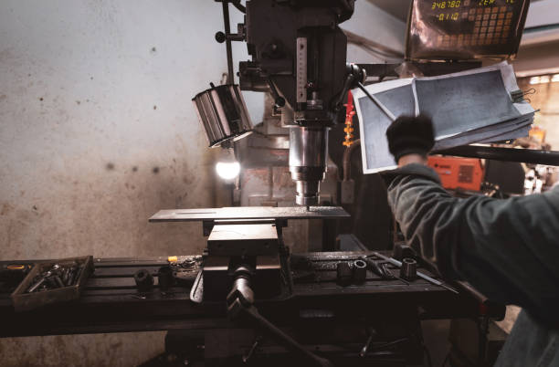 istock Milling machine working near worker with gloves. Tool for cut metal workpiece. Vertical milling machine with cemented carbide milling cutter. Steel manufacturing industry. Milling process. Metalwork. 1334270524