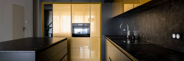 istock Modern black and gold kitchen with kitchen island, panorama 1334271013