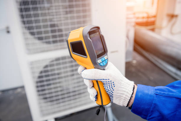 istock Technician uses a thermal imaging infrared thermometer to check the condensing unit heat exchanger. 1334272143