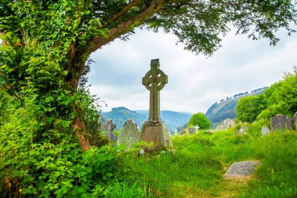 antiguo cementerio y cruz celta en el valle de glendalough, irlanda - celtic cross fotografías e imágenes de stock