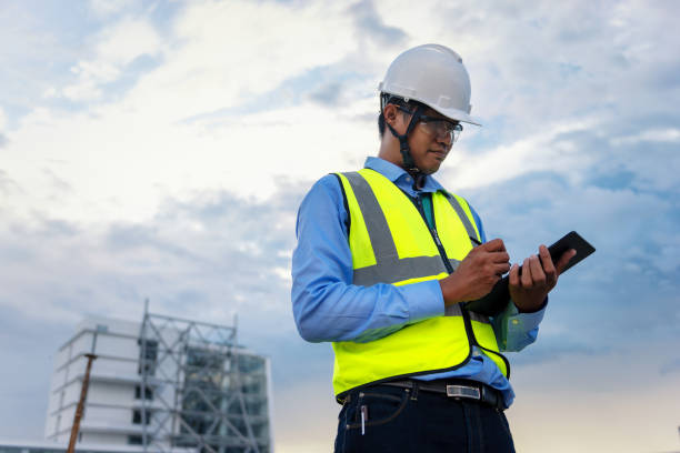 istock Engineering Consulting People on construction site holding tablet in his hand. Building inspector. Construction site checking by technology and business workflow of new building. 1334272858