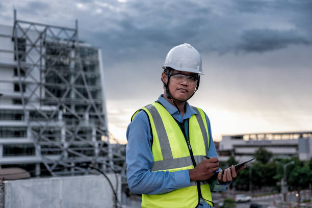 istock Engineering Consulting People on construction site holding tablet in his hand. Building inspector. Construction site checking by technology and business workflow of new building. 1334272859