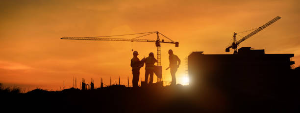 istock Silhouette engineer construction work control and tower crane background on natural sunset sky.,Heavy industry and building construction work concept in banner 1334275013