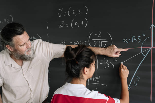 istock Asian Teenager Student doing Maths Exercises on Blackboard with teacher help in High School 1334275098