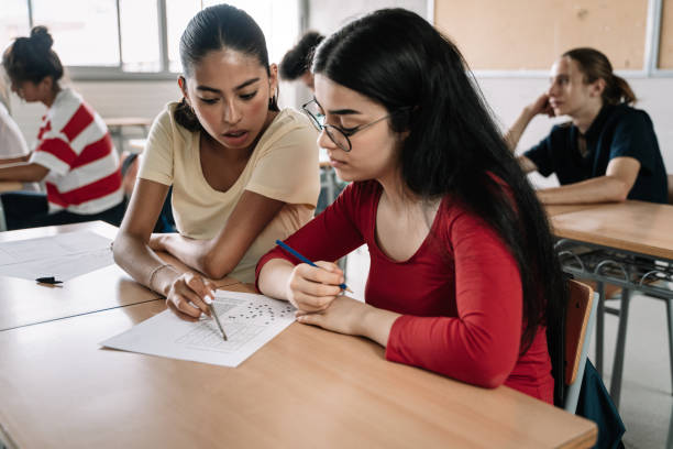 istock Two latin and hispanic female classmates friends doing exercise together in the Secondary School Classroom 1334275114