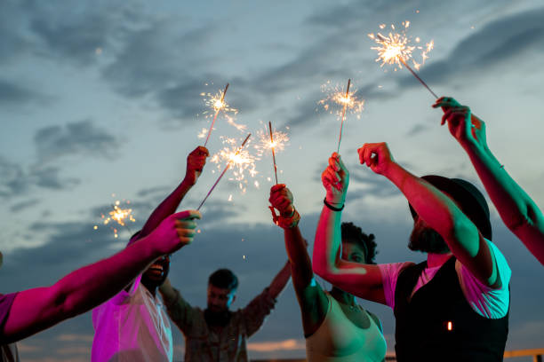 istock Happy young intercultural people dancing with bengal lights 1334276947