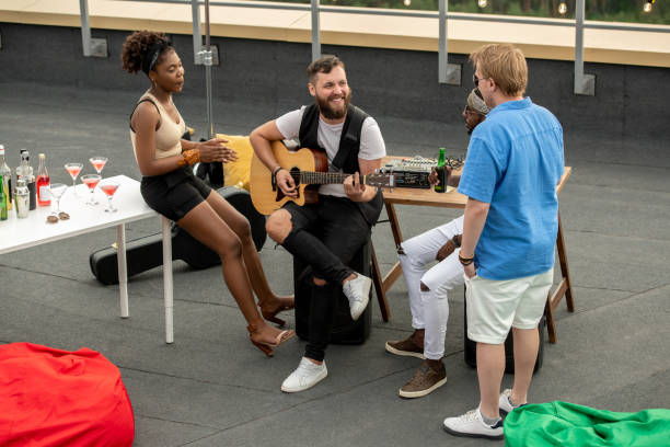 istock Four young intercultural people interacting and having fun at rooftop party 1334277000