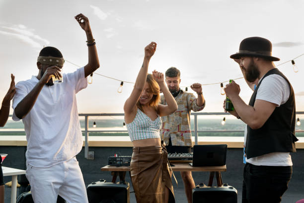 istock Young intercultural friends and deejay dancing together at rooftop party 1334277669
