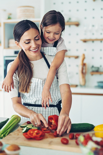 Smiling woman and a little girl together in the kitchen