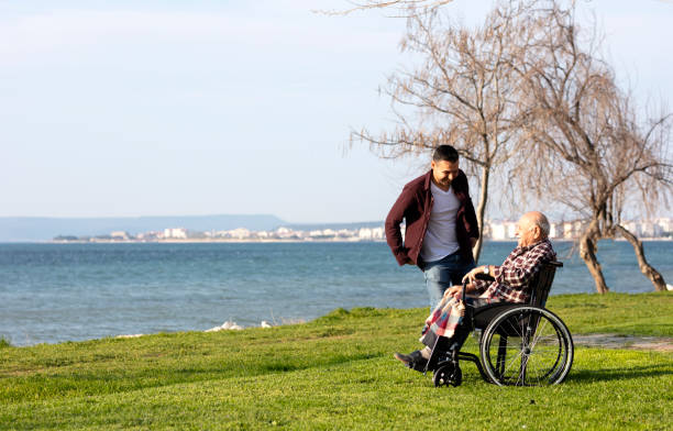 istock Elderly man in wheelchair with young man 1334278892