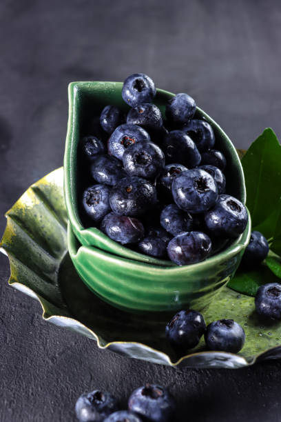 istock Freshly picked blueberries in a bowl. Juicy and fresh blueberries on rustic table. Concept for healthy eating and nutrition 1334279284