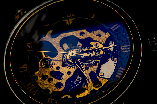 macro winding clock,Skeleton wrist watch with black clock face, macro photo. It is a mechanical watch type in which all of the moving parts are visible