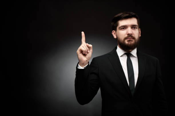 istock Man in suit pointing his index finger up 1334281780