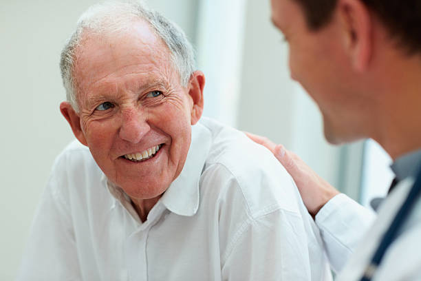 homme médecin avec son patient de parler - homme 65 ans photos et images de collection