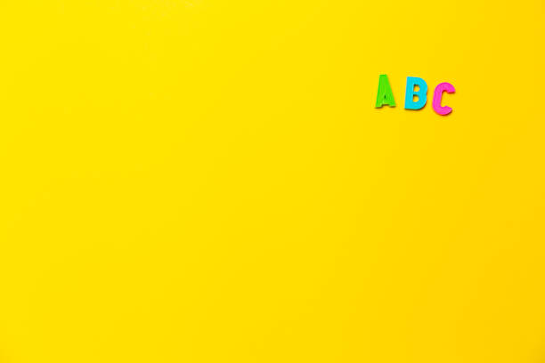 istock Multicolored letters A, B, C of the alphabet on yellow background. Learning foreign language for beginners. Primary school education, grammar lesson. Banner on educational theme with free text space 1334284045