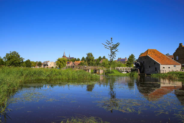istock View over reflecting river pond on old water mill restaurant against deep blue cloudless summer sky 1334284050