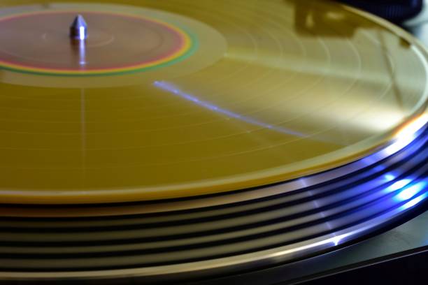 gold colored vinyl record spinning on stereo turntable - lp jazz stockfoto's en -beelden