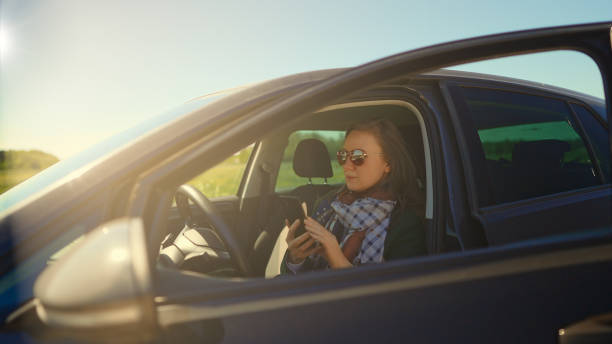 istock Woman sitting in car and using mobile phone. 1334284178