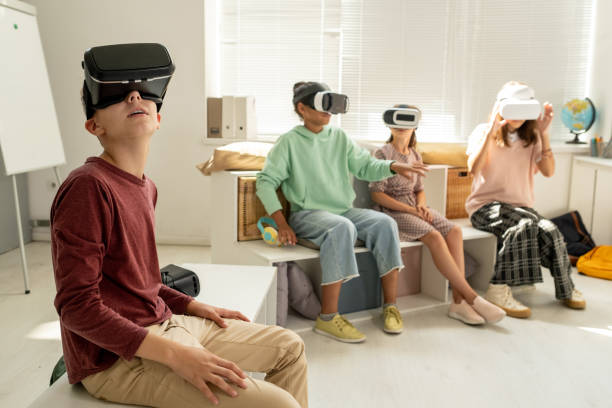 istock Contemporary schoolboy and his classmates watching video presentation 1334284253
