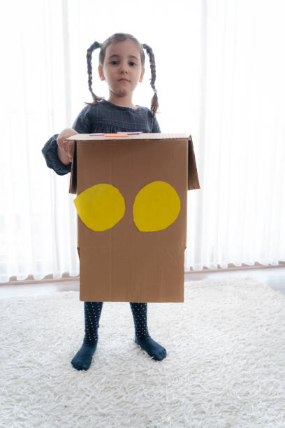 istock Little girl having fun with cardboard box 1334286595