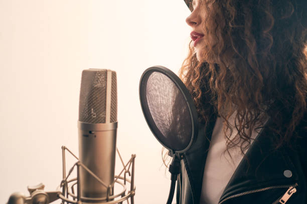istock Pretty female singer recording in music studio 1334287217