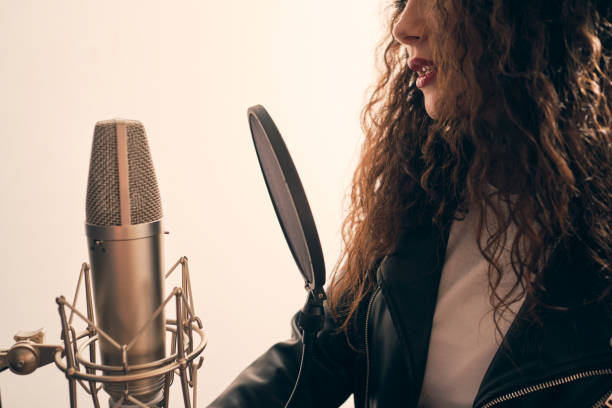 istock Pretty female singer recording in music studio 1334287219