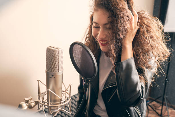 istock Pretty female singer recording in music studio 1334287229